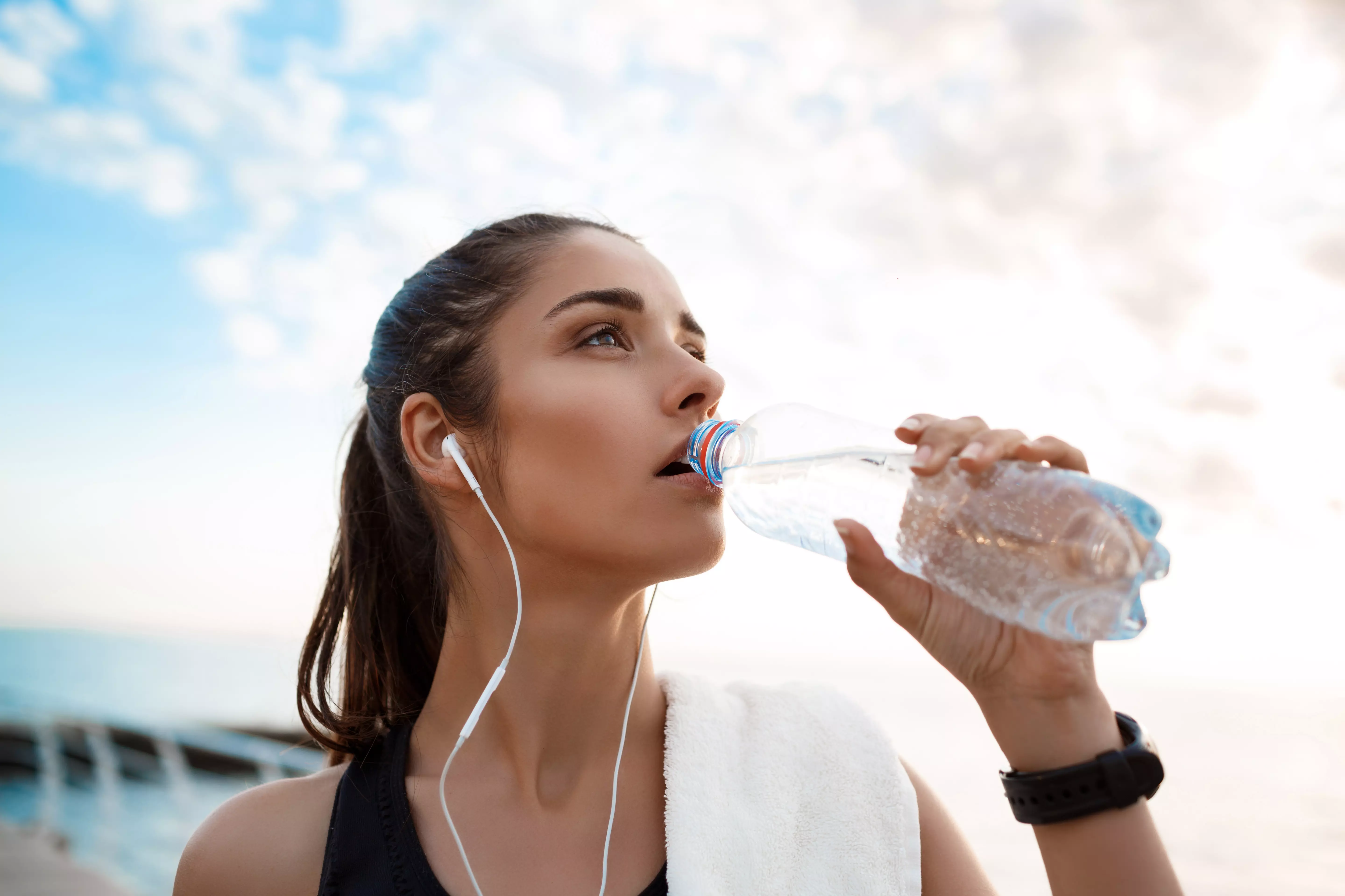 mulher treinando e bebendo água