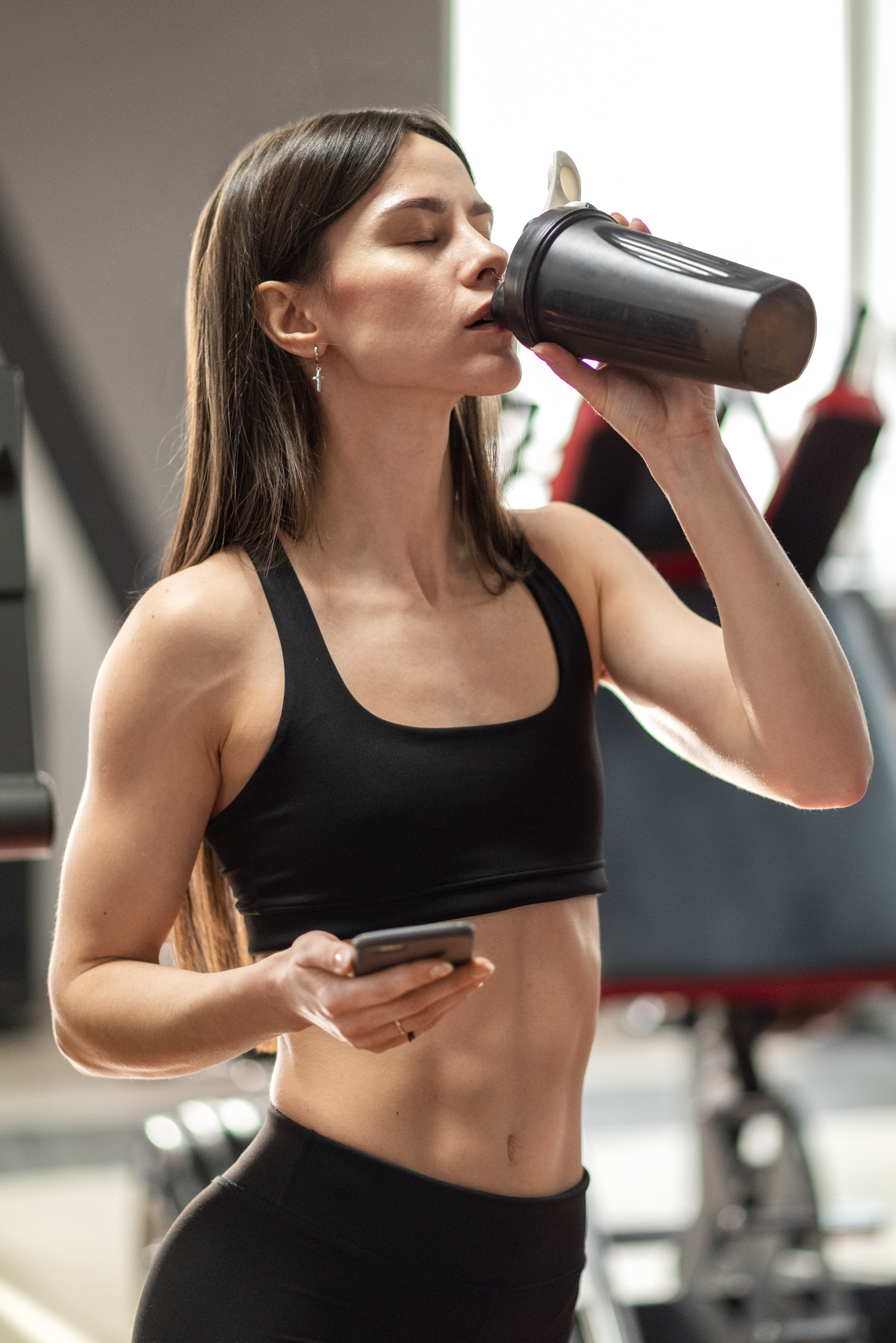 Mulher tomando whey protein na academia